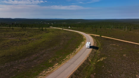 Aerial-view-following-a-RV-driving-down-from-a-fell,-in-Inari-Saariselka,-Finland
