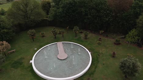 Aerial-view-of-round-fountain-garden-with-lush-greenery