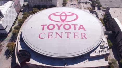 Toyota-Center-Area,-Birdseye-Aerial-View-of-Logo-on-Rooftop,-Houston-TX-USA-on-Sunny-Day-Drone-Shot