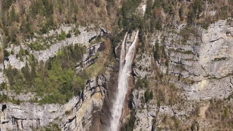 Drone-aerial-view-captures-the-majestic-Seerenbachfälle,-a-spectacular-series-of-waterfalls-nestled-in-the-Amden-Betlis-region-near-Lake-Walensee,-Switzerland