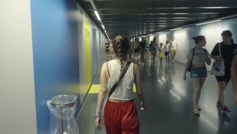 Following-young-caucasian-woman-walking-in-underground-metro-station-in-Barcelona