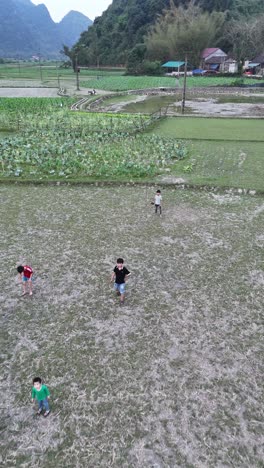 Cao-Bang,-Vietnam---Niños-Jugando-En-Los-Campos,-Vista-Aérea-Vertical