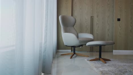 White-Armchair-With-Stool-At-The-Corner-Of-Room