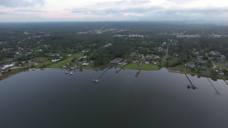 Morning-drone-shot-of-a-coastal-area,-homes-and-docks