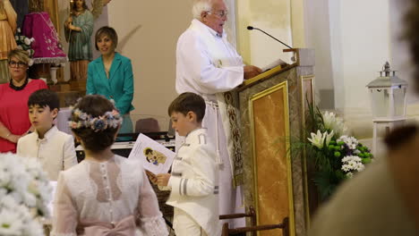 Children-and-priest-during-a-Spanish-Communion-ceremony-in-Zaragoza,-Spain