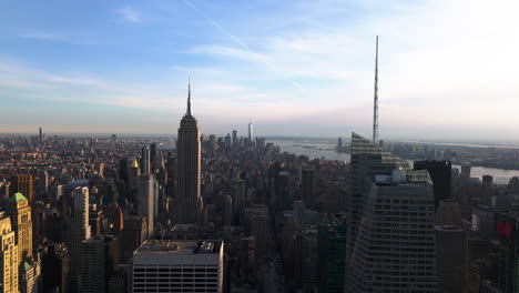 AERIAL:-Manhattan-skyline-and-sunlit-Empire-state-building-from-Times-square,-NY