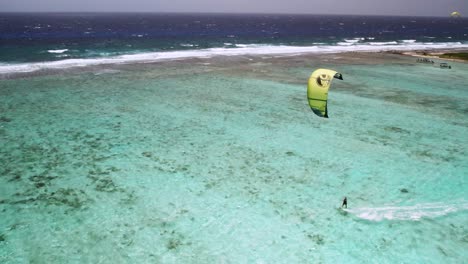 Ein-Kitesurfer-Auf-Türkisfarbenem-Wasser-In-Der-Nähe-Des-Korallenriffs,-Los-Roques,-Luftaufnahme