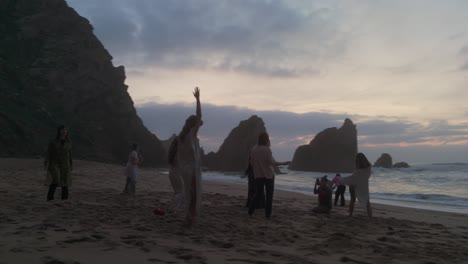 Women-dancing-on-sand-with-huge-cliffs-Background