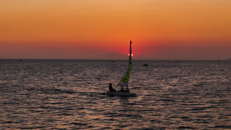 3-Personen-Schlauchboot-Segeln-Bei-Sonnenuntergang-über-Einem-Feurigen-Himmel