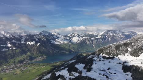 Snowy-majestic-mountains,-lake-with-cloudy-sky,-Glarus,-Switzerland