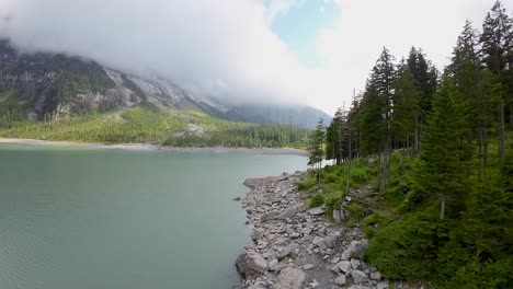 Drone-flight-towards-mountain-Landscape,-aerial-shot-over-a-blue-Oeschinen-lake,-Switzerland,-Europe