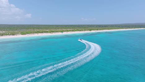 Small-motorboat-lands-on-exotic-white-sand-beach-in-the-Caribbean,-aerial