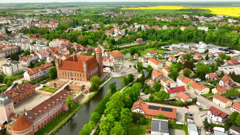 Castle-with-Tower,-River-and-canola-field-in-small-polish-town-of-Lidzbark-Warminski