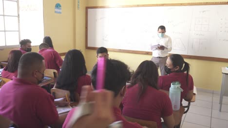 Teacher-in-front-of-students-in-a-public-school-classroom-in-a-poor-area-of-Tegucigalpa,-Honduras