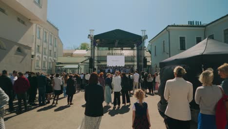 Latvian-audience-listening-to-choir-that-sings-on-stage-during-summer-day