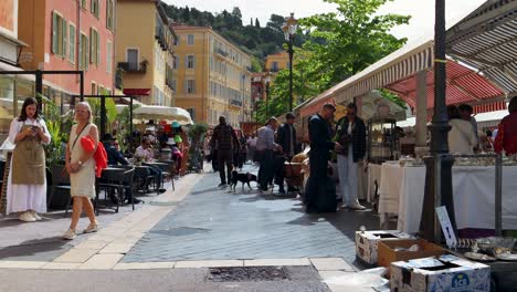 Bustling-antique-market-scene-on-Cours-Saleya,-Nice,-with-shoppers-and-colorful-stalls