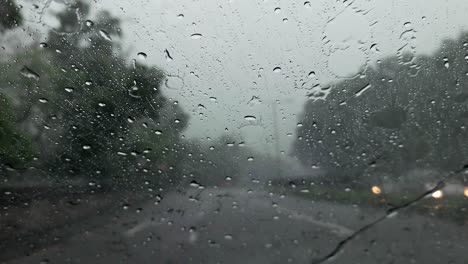 POV-Von-Regen,-Der-Während-Der-Fahrt-In-Hongkong-Auf-Die-Windschutzscheibe-Eines-Autos-Fällt