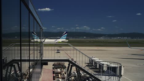 Air-Busan-airplane-on-the-runway-reflecting-in-the-glass-from-the-terminal