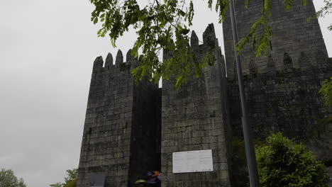 Rain-drops-fly-across-sky-as-tourists-walk-to-entrance-of-tower-protected-castle-on-tour