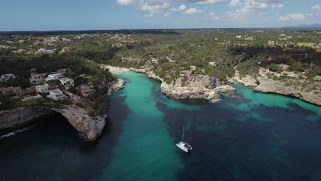 Boat-At-Cala-Llombards-Beach-In-Mallorca,-Aerial-Tracking-Shot