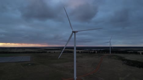 Eolic-wind-turbines-with-blades-rotating-in-rural-landscape-with-cloudy-sky