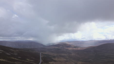 Rain-arriving-in-Cairngorms,-Scotland.-Aerial-descending