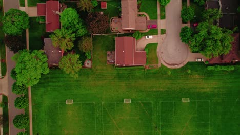 Vista-Aérea-De-Arriba-Hacia-Abajo-De-Casas-En-Los-Suburbios-De-Chicago-Adyacentes-A-Múltiples-Campos-De-Fútbol.