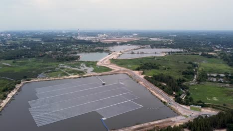 Vista-Aérea-De-Un-Enorme-Panel-Solar-Sobre-El-Agua-En-Una-Zona-Rural,-Granja-Solar-Flotante