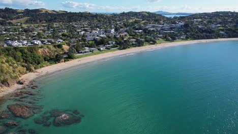 Big-Oneroa-Beach-With-Tranquil-Ocean-In-Waiheke-Island,-New-Zealand---Aerial-Pullback