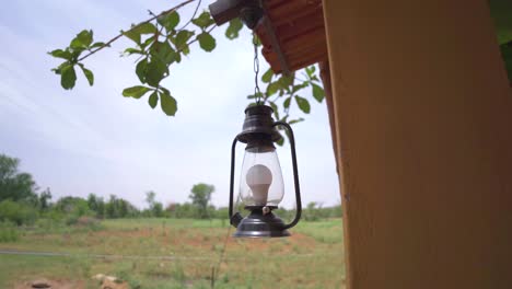 Eine-Moderne-Glühbirne-Laterne-Hängen-Außerhalb-Einer-Dorfhütte-Im-Ländlichen-Indien