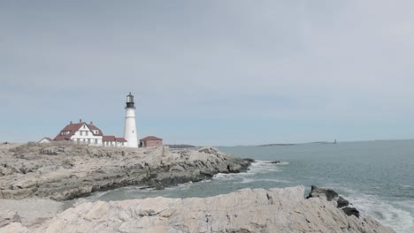 Beautiful-rocky-sea-side-view-of-the-Portland-Maine-Head-Light-light-house-during-a-beautiful-spring-day-with-waves-rolling-into-the-rocky-shore-in-4k