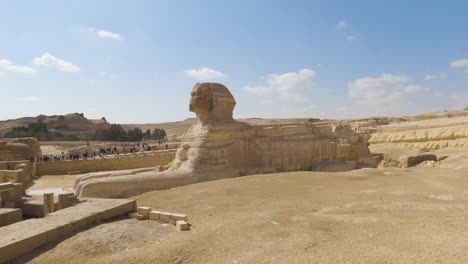 Great-Sphinx-at-entrance-wall-in-desert-with-large-tour-group-off-in-distance