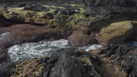 Rocas-De-Lava-Cubiertas-De-Musgo-Con-Una-Piscina-De-Marea-En-Mosteiros,-Sao-Miguel,-Escena-De-Naturaleza-Serena