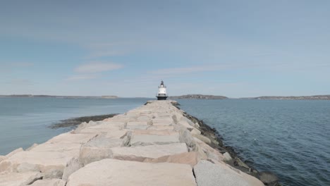 Spring-Point-light-house-off-in-the-distance-at-the-end-of-a-rocky-peer-in-Portland-Main-in-4k