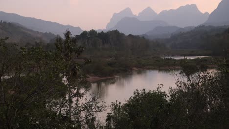 Puesta-De-Sol-Rosa-Detrás-De-Picos-Irregulares-En-La-Ciudad-Montañosa-De-Nong-Khiaw-En-Laos,-Sudeste-Asiático