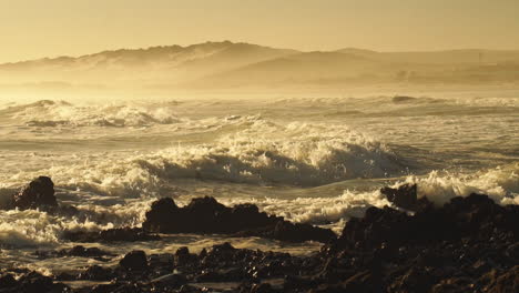 Rough-Sea-Waves-Crashing-On-Rocky-Shoreline-During-Golden-Afternoon---Wide-Pan-Shot
