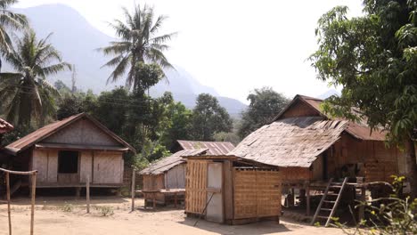 small-village-huts-and-palm-trees-in-the-mountain-town-of-Nong-Khiaw-in-Laos,-Southeast-Asia