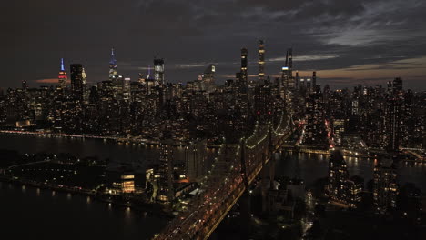 Nyc-Nueva-York-Antena-V356-Drone-Sobrevuelo-Puente-De-Queensboro-Sobre-El-Río-Este-Capturando-La-Isla-Roosevelt-Iluminada-Y-El-Paisaje-Urbano-Al-Anochecer-Del-Centro-De-Manhattan---Filmado-Con-Mavic-3-Pro-Cine---Septiembre-De-2023