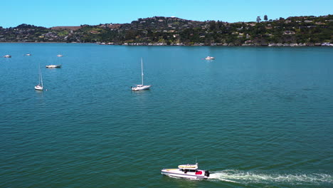 Drone-circling-a-boat-in-front-of-the-Sausalito-marina,-in-sunny-California,-USA