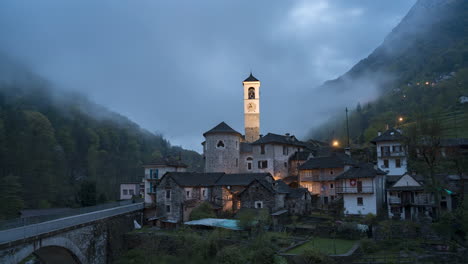 Día-A-Noche-En-La-Capilla-Del-Valle-De-Verzasca-En-Un-Día-Nublado-En-Lavertezzo-Suiza