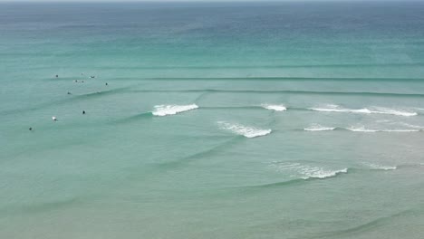 Olas-Del-Océano-Cruzando-Unas-Sobre-Otras-A-Lo-Largo-De-Una-Playa-En-Cornwall-Con-Surfistas