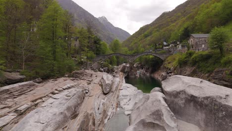 Aerial-dolly-upstream-to-Ponte-Dei-Salta-in-Lavertezzo-Verzasca-Switzerland