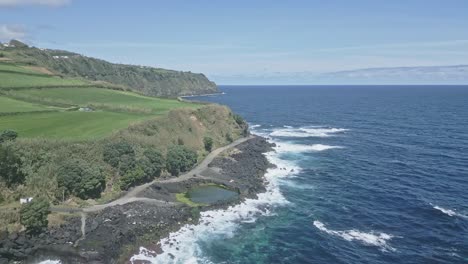 Birdseye-view-of-coastal-road-and-volcanic-rocky-cliffs-of-Santo-Antonio,-Sao-Miguel-of-Azores-islands