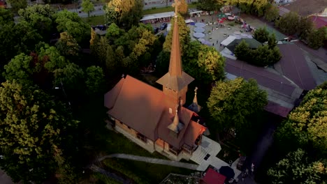 4k-cinematic-drone-stock-footage-flying-downwards-on-a-wooden-church-with-a-stunning-view-of-the-buildings-being-lit-by-sunset