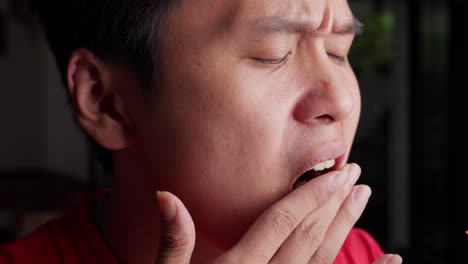 Portrait-shot,-Asian-man-chewing-eats-Vegetarian-olive-pizza-with-his-hands