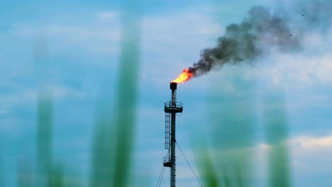 Industrieller-Fackelturm-Mit-Himmelblauen-Wolken-Im-Hintergrund