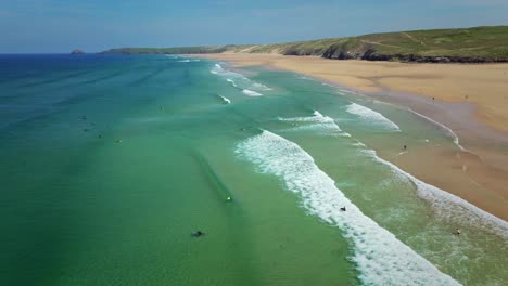 Perranporth-Beach-Surfers-with-Turquoise-Ocean-Waves-Along-the-Cornish-Coastline,-UK