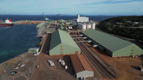 Buildings-of-mining-factory-connecting-with-pipelines-at-port-of-Esperance,-Australia