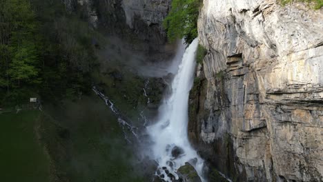 Toma-Aérea-De-Maravillosas-Cascadas-Que-Fluyen-Desde-La-Montaña-Rocosa,-Seerenbach-Falls-Amden,-St