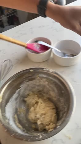 Vertical-video-of-rolling-a-vegan-donut-from-a-batter-and-adding-to-a-pan-to-make-vegan-donuts